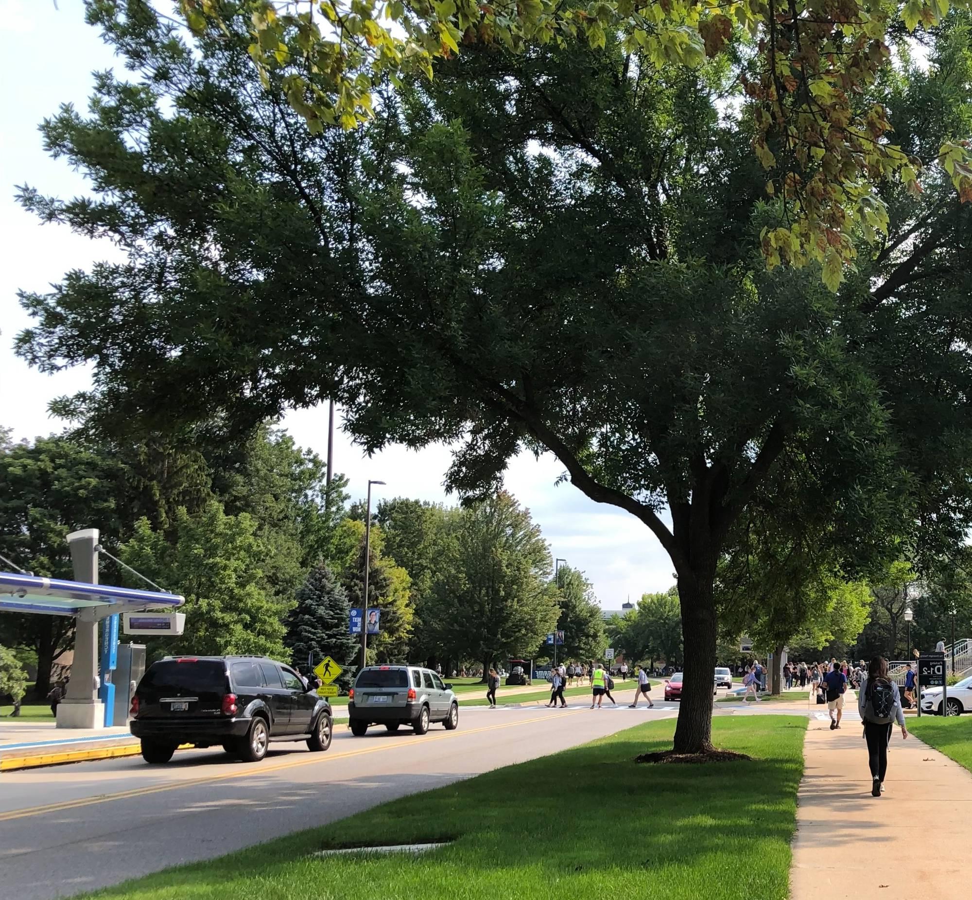 GVSU campus with students walking by Mackinac and bus stop